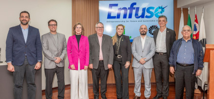A foto mostra oito autoridades em trajes formais, posando em frente a uma tela com o logo "Enfuse". Ao fundo, bandeiras do Brasil, do Estado de São Paulo, da cidade de Campinas e da Unicamp são visíveis. Fim da descrição.